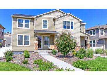 Charming two-story home featuring a landscaped front yard with a sidewalk leading to the front door at 5156 Bittercress Rd, Brighton, CO 80640