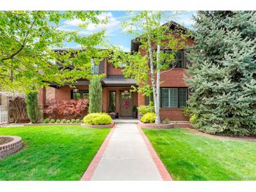 Two-story brick home with manicured lawn, mature trees, and a welcoming front entrance at 2153 S Columbine St, Denver, CO 80210