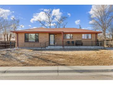 Charming brick home with a well-kept front yard and inviting front porch, creating a warm and welcoming curb appeal at 1275 Otis St, Lakewood, CO 80214