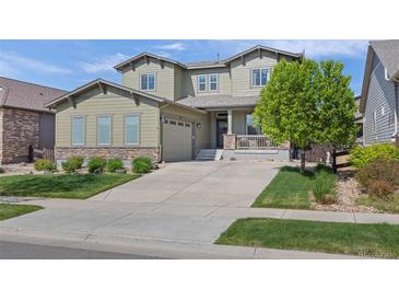 Charming two-story home with an attached garage, manicured lawn, and a welcoming front porch at 525 Grenville Cir, Erie, CO 80516