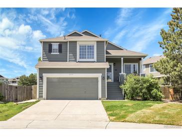 Charming two-story home with well-maintained landscaping, a two-car garage, and a welcoming front porch at 8935 Sleepy Grass Ct, Parker, CO 80134
