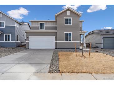 Charming two-story home featuring a two-car garage and neutral gray siding at 5718 Ranch St, Mead, CO 80504