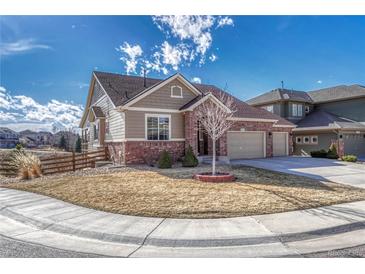 Charming ranch-style home with a brick and tan exterior, three-car garage, and well-maintained front yard at 4883 S Sicily St, Aurora, CO 80015