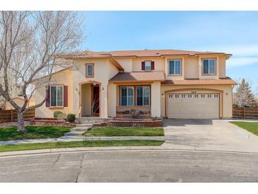 Charming two-story home with manicured lawn, arched entrance, and a two car attached garage at 16650 E 107Th Ct, Commerce City, CO 80022