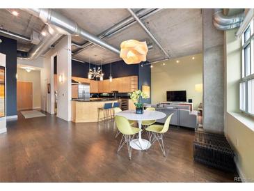 Open-concept living space with a modern kitchen, dining area, and stylish decor with exposed ductwork and concrete ceilings at 1890 Wynkoop St # 806, Denver, CO 80202