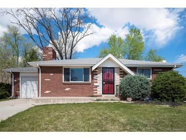 Charming brick home with a well-manicured lawn and inviting front entrance, featuring a red storm door at 8209 Benton Way, Arvada, CO 80003