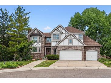 Charming two-story home with brick and neutral trim and a three-car garage at 9117 Buck Hill Dr, Highlands Ranch, CO 80126