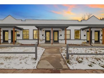 Charming townhome featuring a white brick facade, covered front porch, and walkway at 3005 California St, Denver, CO 80205