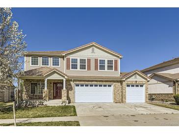 Charming two-story home featuring brick accents, a three-car garage, and a well-maintained front lawn at 5131 Netherland St, Denver, CO 80249