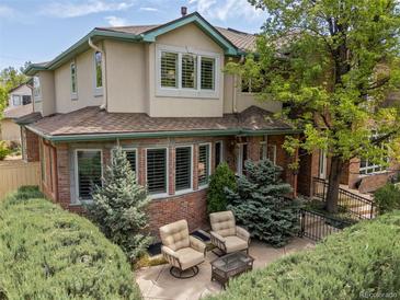 Charming home exterior with a private brick patio, comfortable seating, and manicured landscaping at 344 Saint Paul St, Denver, CO 80206
