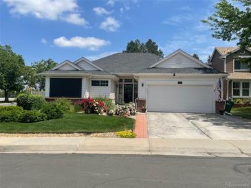 Charming single-story home with a well-manicured lawn and colorful flower beds at 9798 Grove St, Westminster, CO 80031