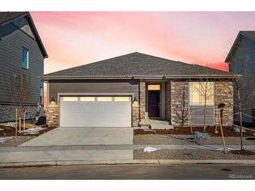 One-story home with stone and siding exterior, attached garage, and landscaping at 1927 S Coolidge Way, Aurora, CO 80018