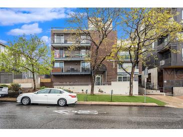 Brick building exterior with ample parking and landscaping at 830 N Sherman St # 106, Denver, CO 80203