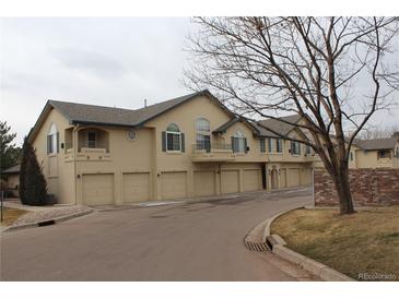 Townhome complex showcasing multiple units with attached garages and well-maintained landscaping on a cloudy day at 8603 E Dry Creek Rd # 211, Englewood, CO 80112