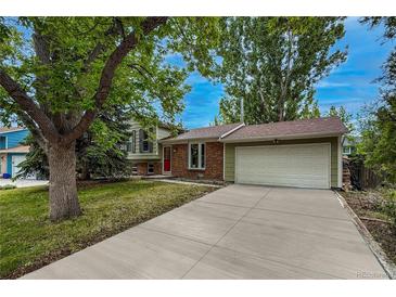 Charming home featuring a long driveway, brick accents, well-maintained lawn, and mature trees at 117 Sandler Dr, Lafayette, CO 80026