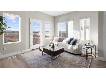 Bright living room featuring a comfortable sofa, stylish coffee table, and large windows with natural light at 2620 S Delaware St # 3, Denver, CO 80223