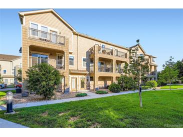 Charming townhome showcases a private balcony and is surrounded by lush green landscaping at 11250 Florence St # 22B, Commerce City, CO 80640