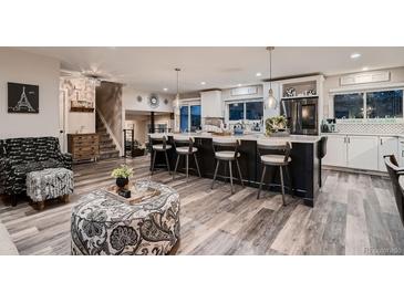 Open concept kitchen with an island, seating, and modern appliances at 5611 W Bates Ave, Denver, CO 80227