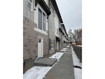 New townhouses with gray brick and white siding, and a walkway at 6643 W 52Nd Ave # C, Arvada, CO 80002