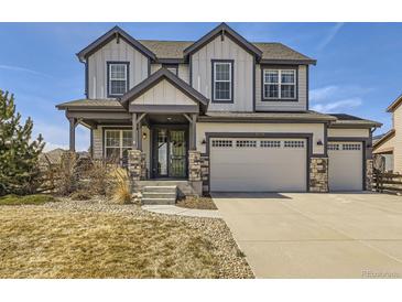 Charming two-story home showcasing stylish gray siding, stone accents, and a welcoming front porch at 8739 Culebra St, Arvada, CO 80007