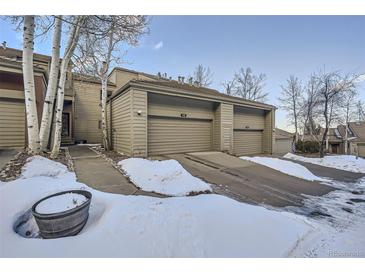 Charming townhome exterior featuring a two-car garage and snowy front yard at 748 Ridgeside Dr, Golden, CO 80401