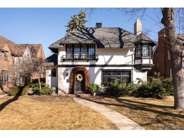 Charming Tudor-style home featuring a decorative wreath, manicured landscaping, and a welcoming walkway to the front door at 124 N Marion St, Denver, CO 80218