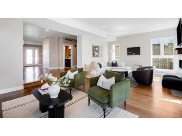Inviting living room with green chairs, stylish decor, and a view into other parts of the house at 1265 Niagara St, Denver, CO 80220