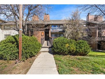 Charming brick condo featuring a walkway entrance, balcony, and well-maintained landscaping at 14602 E 2Nd Ave # 204C, Aurora, CO 80011