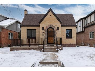 Charming brick home featuring a stone entryway, well-maintained landscaping and a classic peaked roof design at 475 S Race St, Denver, CO 80209