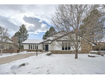 Snow-covered front yard of a remodeled midcentury modern home at 2133 S Parfet Dr, Lakewood, CO 80227