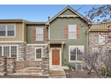 Inviting two-story townhome featuring a stone facade, wood accents, and a cozy front porch at 821 Stony Mesa Pl, Castle Rock, CO 80108