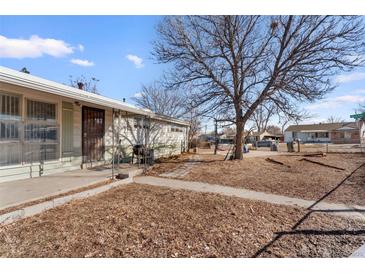 Modest single-story home with a lawn on a sunny day at 1599 W Beekman Pl, Denver, CO 80221