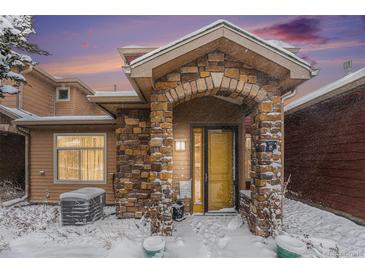 Snow covered front entrance of charming townhome with stone accents at 8551 Gold Peak Dr # B, Highlands Ranch, CO 80130