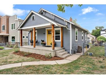 Charming home with inviting front porch, yellow door, and well-manicured yard at 4166 N Yates St, Denver, CO 80212