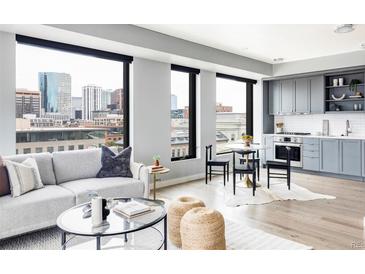 Bright open concept living space featuring city views, sleek furniture, and a modern kitchen at 1750 Wewatta St # 740, Denver, CO 80202