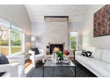 Bright living room with a cozy fireplace, neutral tones, and stylish decor provides a welcoming space for relaxation at 2645 S Xanadu Way # D, Aurora, CO 80014