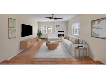 Bright living room features a stone fireplace, modern furnishings, and hardwood floors at 15650 E Eldorado Dr, Aurora, CO 80013