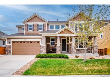 Charming two-story home featuring a meticulously manicured lawn, stone accents, and an attached two-car garage at 3421 E 143Rd Dr, Thornton, CO 80602