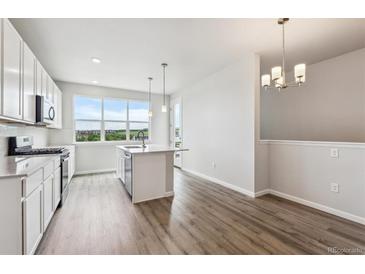 Bright kitchen featuring stainless steel appliances, kitchen island, and views from the large window at 457 Interlocken Blvd # 106, Broomfield, CO 80021
