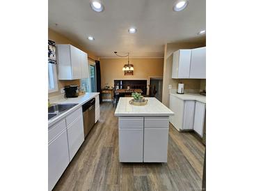 Bright kitchen with white cabinets, tile countertops, and an island with seating at 2034 S Truckee St, Aurora, CO 80013