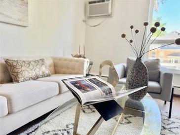 Bright living room features stylish furniture, decor, and a glass coffee table at 1050 N Lafayette St # 408, Denver, CO 80218