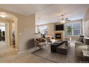 Bright living room features a fireplace and access to the kitchen at 17497 Nature Walk Trl # 101, Parker, CO 80134