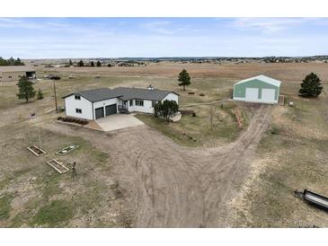 Expansive acreage featuring a charming single-story home with a large garage and a sizable storage building at 2845 Cherry Way, Parker, CO 80138