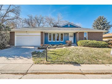 Charming single-story home with a well-manicured lawn, brick accents, and attached garage at 1701 S Newport Way, Denver, CO 80224