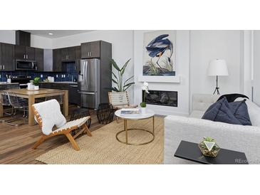 Open concept living room featuring a modern fireplace and dining area adjacent to the kitchen at 2857 S Pancratia St, Denver, CO 80236