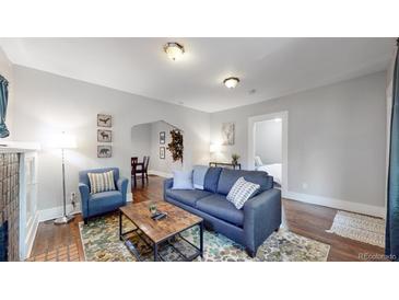 Inviting living room with a comfortable blue sofa, a decorative rug, and a doorway to the bedroom at 1137 Colorado Blvd, Denver, CO 80206