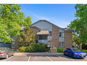 Two-story condo building with stone accents and well-maintained landscaping at 8055 W Eastman Pl # 104, Lakewood, CO 80227