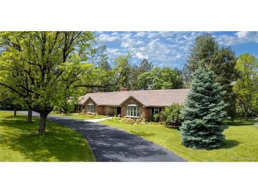 Charming single-story home featuring a beautifully landscaped front yard with mature trees and a long driveway at 39 Sedgwick Dr, Cherry Hills Village, CO 80113