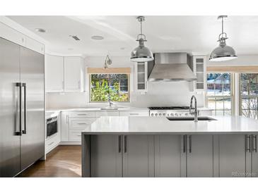 Bright, modern kitchen with stainless steel appliances, white cabinetry, and a large center island at 39 Sedgwick Dr, Cherry Hills Village, CO 80113