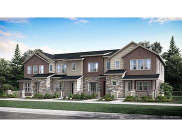 Beautiful townhome featuring stone accents, a covered porch, and manicured landscaping for excellent curb appeal at 712 N Bently St, Watkins, CO 80137